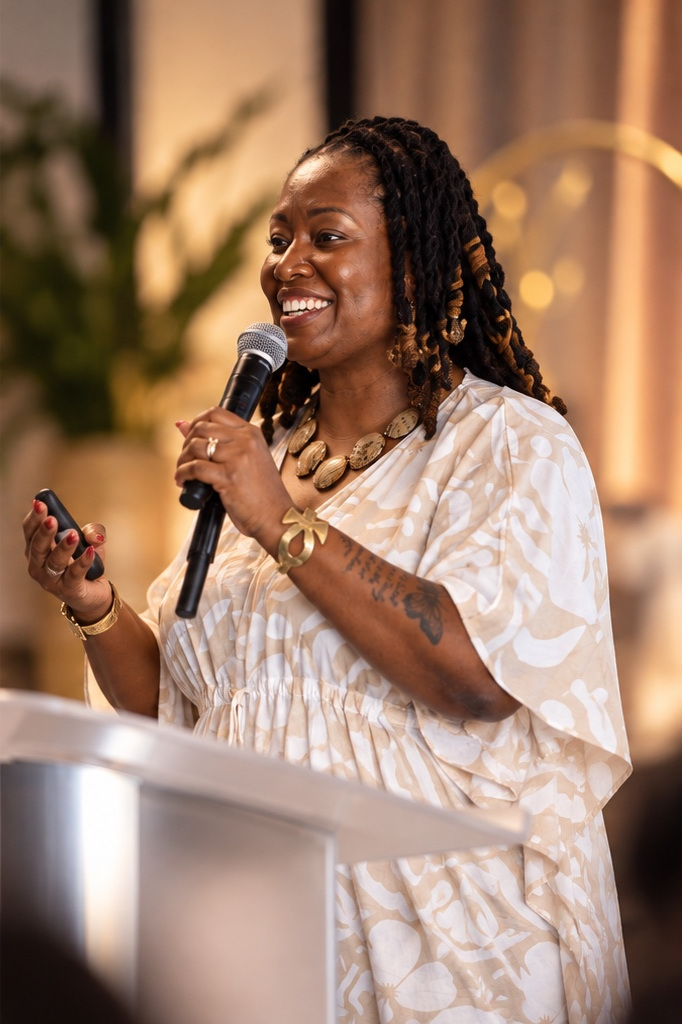 Dr. Lady J smiling and speaking into a microphone